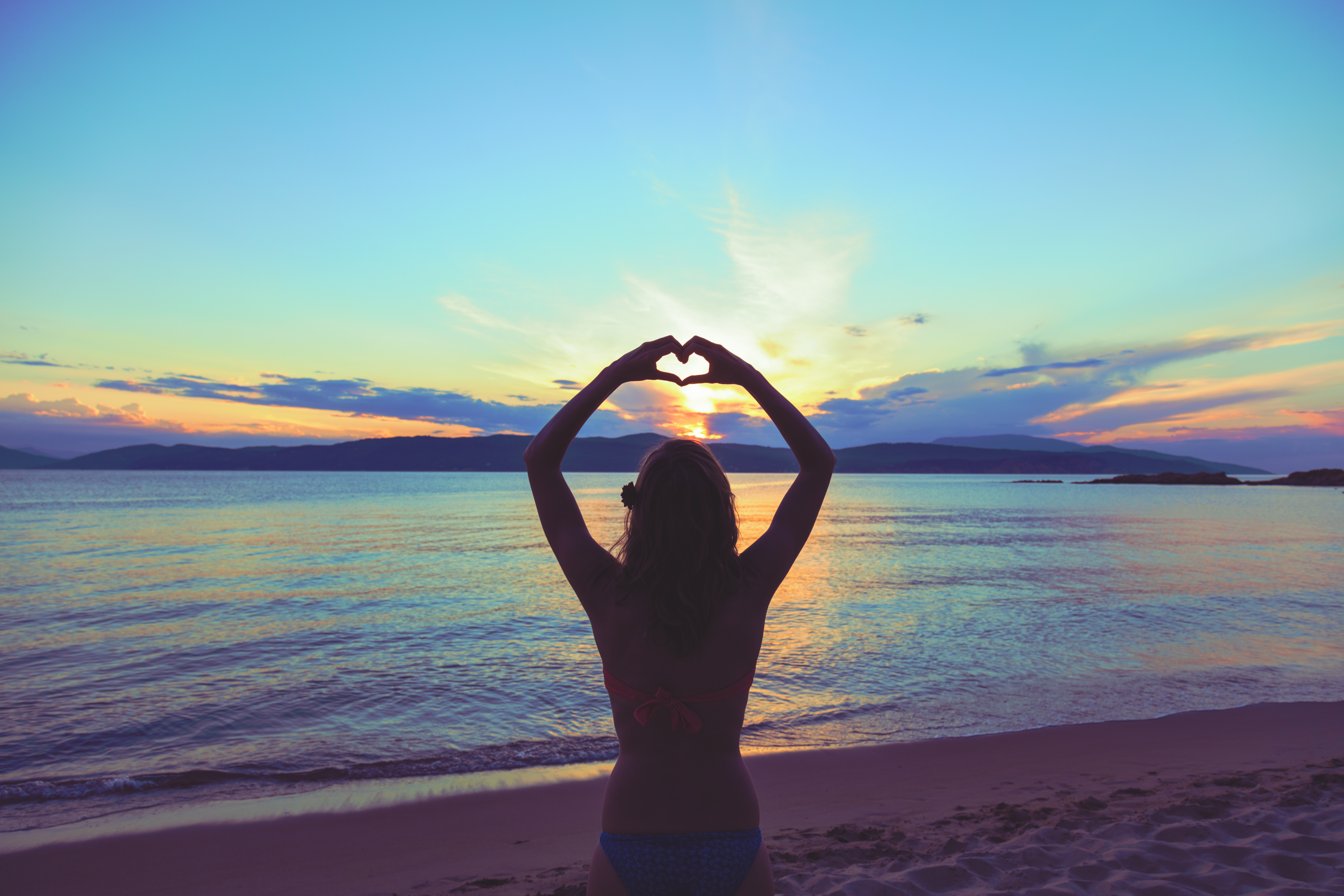 girl,holding,a,heart,shape,for,the,ocean,/,sea.